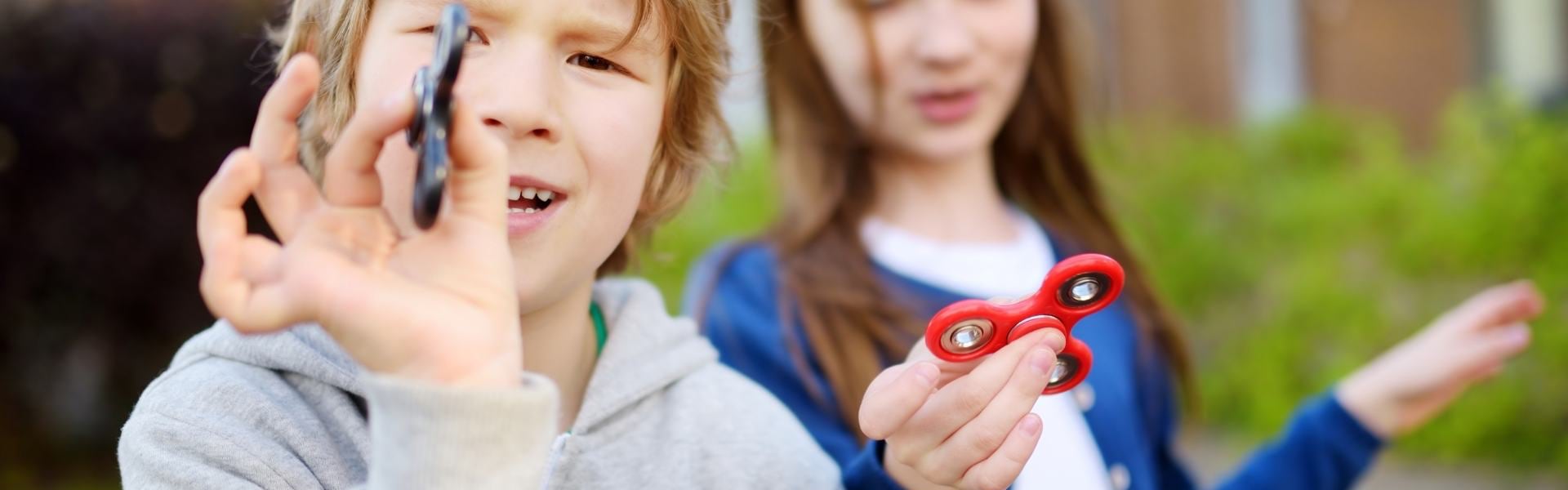 Young boy and girl playing with fidget spinners.
